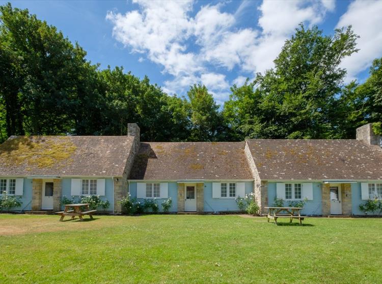How did the architect Sir Bertram Clough Williams-Ellis come to design holiday cottages at Farringford?